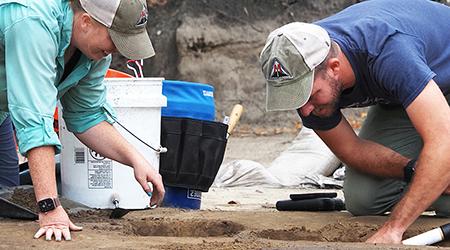 学生们在考古挖掘中挖掘.